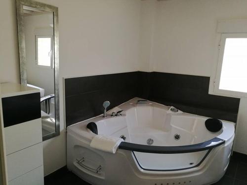 a white tub in a bathroom with a mirror at Gredos Loft in Arenas de San Pedro