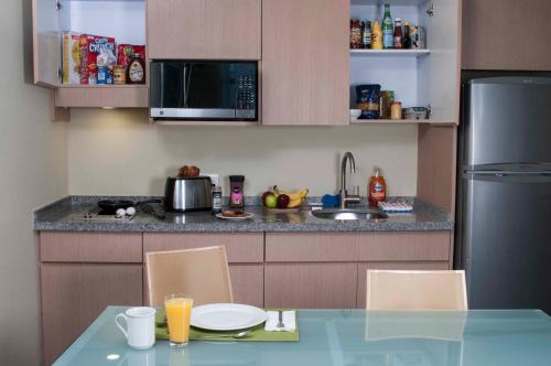 a kitchen with a table with chairs and a refrigerator at Stadia Suites Mexico City Santa Fe in Mexico City