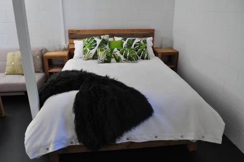 a bed with a black furry blanket on it at The Jungle Stays in Millaa Millaa