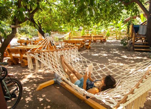 a woman laying in a hammock reading a book at Chimera Pia Aparts in Cıralı