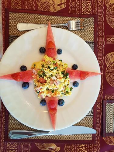 un plato con una rodaja de sandía y bayas en él en Gîte Le Trésor Caché Bed & Breakfast, en Chelsea