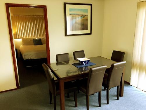 a dining room table with a laptop on it at Admiral Motor Inn in Rosebud