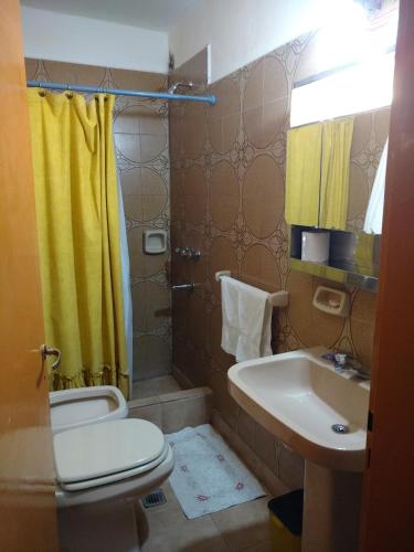 a bathroom with a toilet and a sink at Departamentos Chiquina in Las Grutas