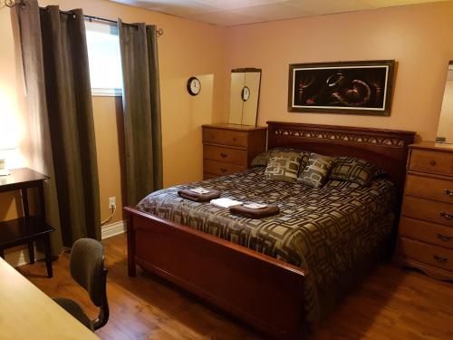 a bedroom with a bed and a dresser and a window at Gîte Le Trésor Caché Bed & Breakfast in Chelsea