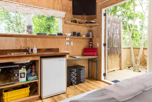 a kitchen with a sink and a refrigerator in a room at Palm Beach Bungalows in Palm Beach