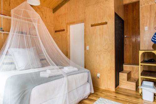 a bedroom with a bed with a mosquito net at Palm Beach Bungalows in Palm Beach
