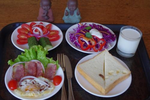 a tray with four plates of food on a table at Artistic-Suite in Lijiang