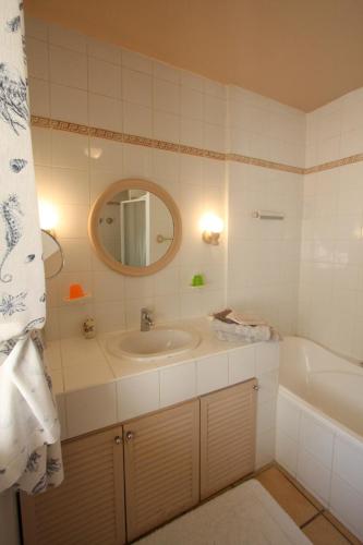 une salle de bain avec un lavabo, une baignoire et un miroir dans l'établissement Mas Alpilles Soleil, à Saint-Rémy-de-Provence