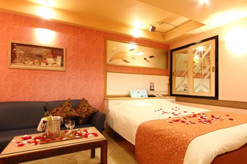 una habitación de hotel con una cama y una mesa con rosas. en Restay Fuchu (Adult Only) en Fuchu