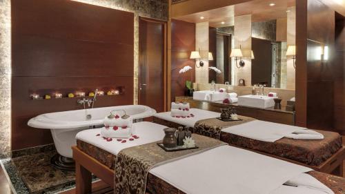 a bathroom with two sinks and a toilet and a tub at Hotel Indonesia Kempinski Jakarta in Jakarta
