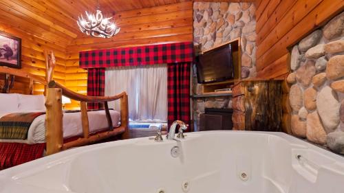 Best Western Merry Manor Inn في ساوث بورتلاند: حوض استحمام في غرفة مع غرفة نوم