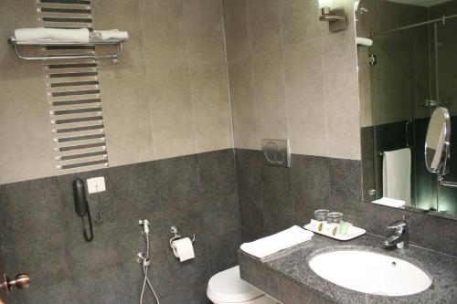 a bathroom with a sink and a toilet and a mirror at Serene Sriperumbudur in Kāndūr