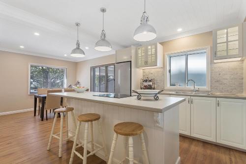 a kitchen with a large island with bar stools at Hamptons at The Bay in Deception Bay