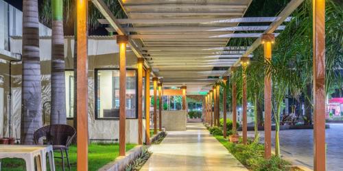 a hallway with palm trees in a building at Pushpak Resort in Shirdi