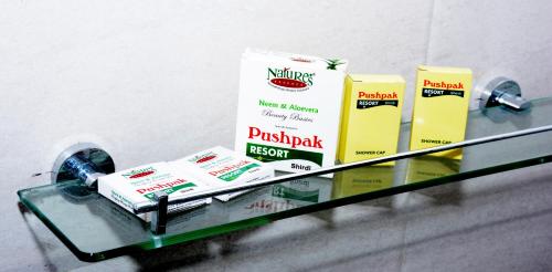 a shelf with three products on top of it at Pushpak Resort in Shirdi