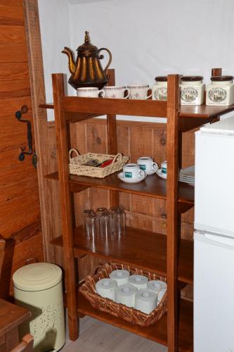 a wooden shelf with dishes and a tea kettle on it at Alėjos Ąžuolas in Leipalingis
