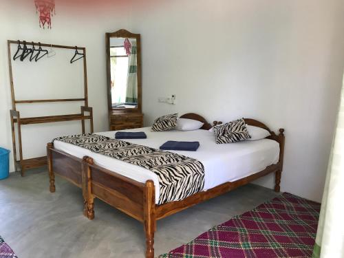 a bed in a room with a zebra print mattress at Nice Place Beach Hotel in Arugam Bay