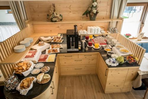 een ontbijttafel in een keuken met eten erop bij Garnì Lasteis B&B - apartments in La Villa