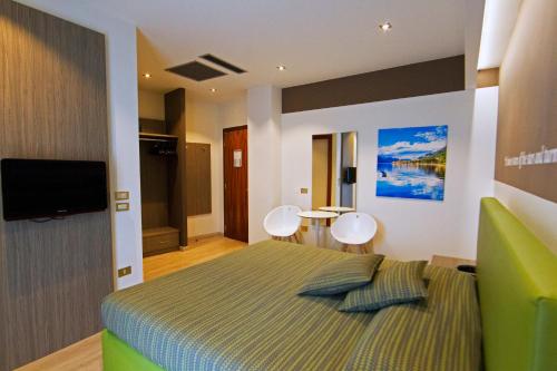 a bedroom with a bed and a television and a table at Hotel Ideal in Sirmione