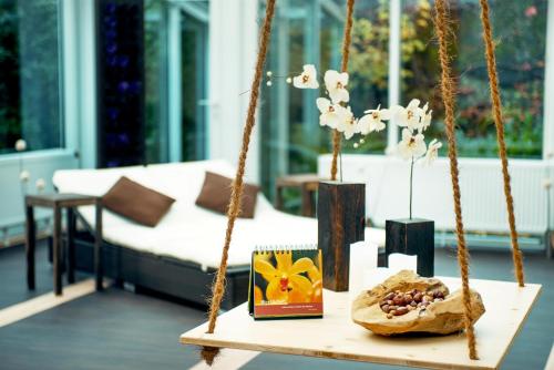 a swing in a living room with a table with a pastry at Hotelpark der Westerwald Treff in Oberlahr