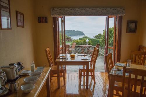 Church Hill Boutique Lodge & Restaurant في هاف مون باي: غرفة طعام مع طاولة وإطلالة على الفناء