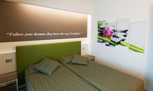 a bedroom with a bed with a picture on the wall at Hotel Ideal in Sirmione
