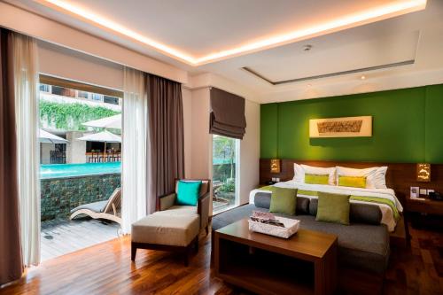 ein Schlafzimmer mit einem Bett und einer grünen Wand in der Unterkunft d'primahotel Petitenget Seminyak 2 in Seminyak