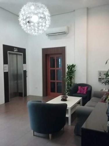 a living room with a table and chairs and a chandelier at Ginasuite Hotel in Bandar Seri Begawan