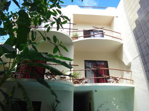 a white building with balconies and plants at Kinbe Hotel Boutique in Playa del Carmen