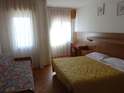 a bedroom with a bed and a desk and a window at Al Bersagliere in Noale