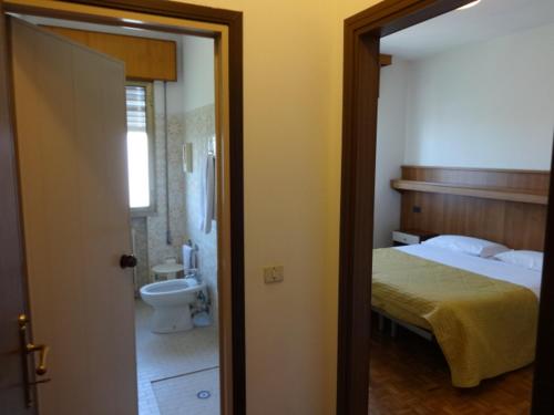 a bedroom with a bed and a bathroom with a sink at Al Bersagliere in Noale