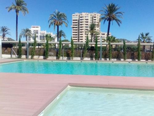 a large swimming pool with palm trees and buildings at Mirador de Calpe in Calpe