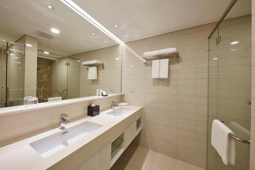 La salle de bains est pourvue de 2 lavabos et d'un grand miroir. dans l'établissement Sunway Velocity Hotel Kuala Lumpur, à Kuala Lumpur