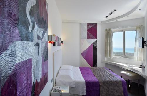 a bedroom with a bed and a sink and a window at Hotel Exclusive in Agrigento