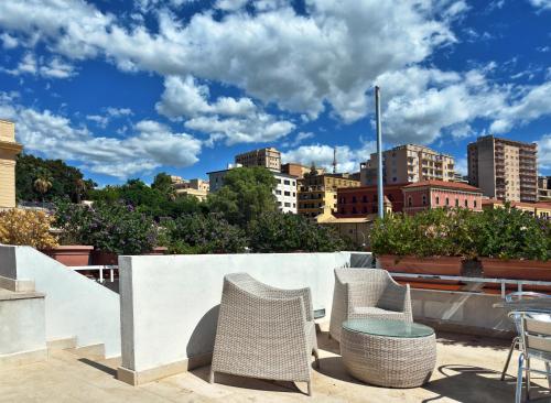 a patio with chairs and tables and a city skyline at Hotel Exclusive in Agrigento