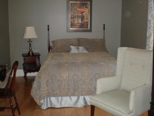 a bedroom with a bed and a chair at Spanish Bay Inn, CANADA in Sydney