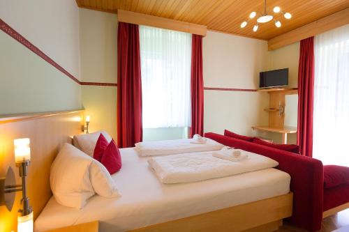 a bedroom with two beds with red and white pillows at Villa Marienhof in Annenheim