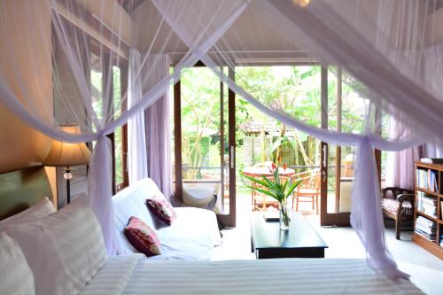 um quarto com uma cama de dossel em Griya Sriwedari em Ubud