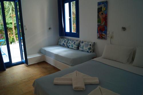 Zimmer mit einem Bett und einem Fenster mit einem Sitz in der Unterkunft Hotel Minoa in Katápola
