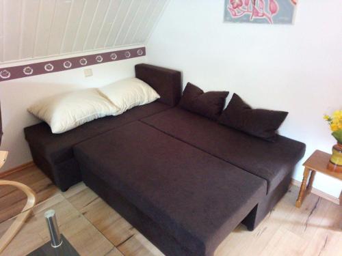 a black couch sitting in a living room at FeWo Falke in Halberstadt