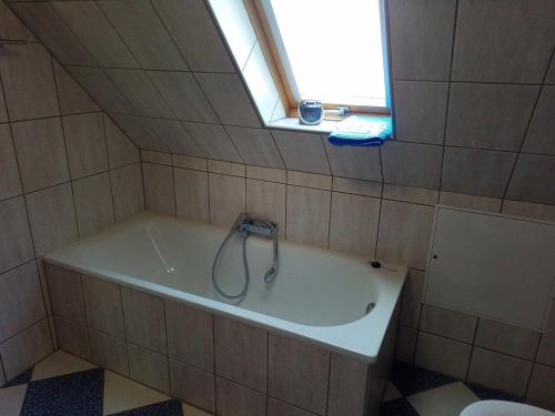 a bath tub in a bathroom with a window at FeWo Falke in Halberstadt