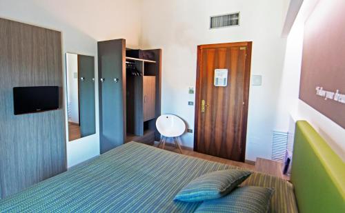 a small bedroom with a bed and a television at Hotel Ideal in Sirmione