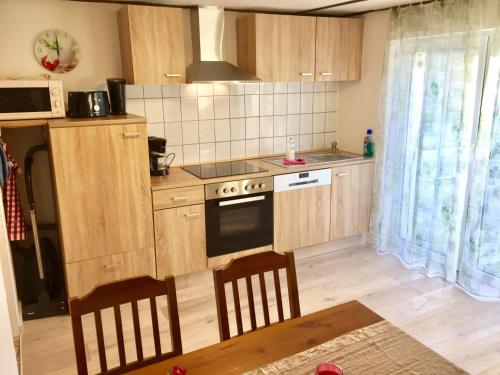 a kitchen with wooden cabinets and a stove top oven at Haus auf der alten Düne 2 in Prerow