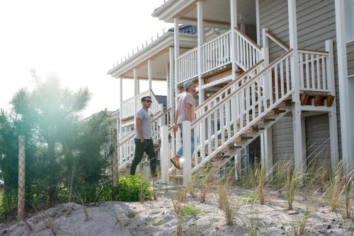 two men walking up the stairs of a house at Beach Apartments Heiligenhafen in Heiligenhafen