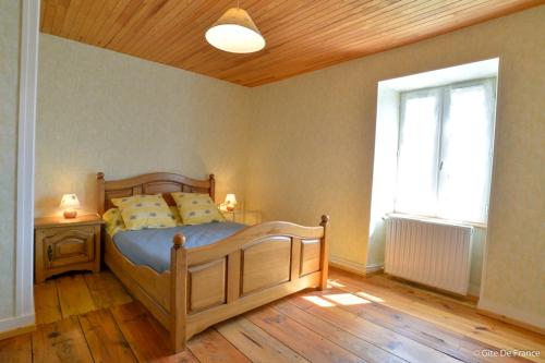 a bedroom with a wooden bed and a window at chantacalme in Montboissier