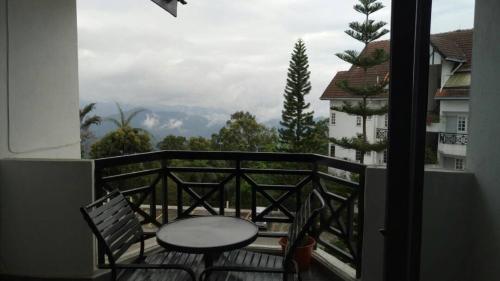 a table and chairs on a balcony with a view at FH Comfy Home in Bukit Fraser
