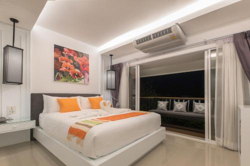 a bedroom with a large white bed and a window at Chiangmai Midpoint Activity Hostel in Chiang Mai