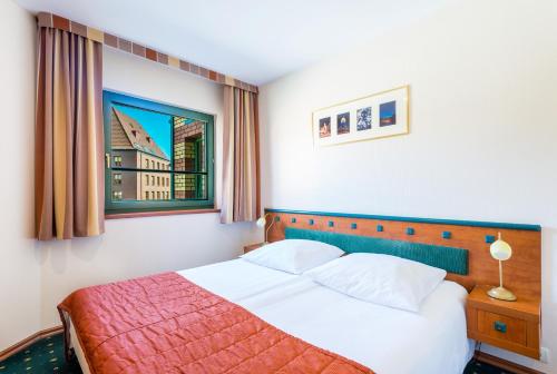 - une chambre avec un lit et une fenêtre dans l'établissement Qubus Hotel Gorzów Wielkopolski, à Gorzów Wielkopolski