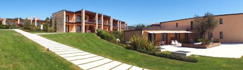 a house with a lawn and a building at Relais Rosa Dei Venti -Ciao Vacanze- in Moniga