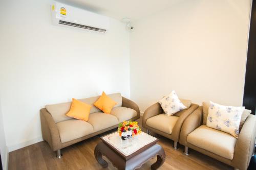 a living room with two couches and a coffee table at Chiangmai Midpoint Activity Hostel in Chiang Mai